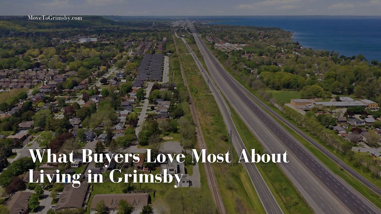 Aerial view of Grimsby, Ontario: the QEW and rail corridor beside leafy residential streets along Lake Ontario.